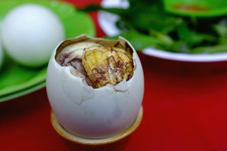 Hình ảnh minh họa mẹ sau sinh đang ăn trứng vịt lộn